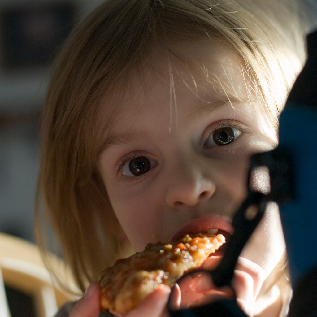 Photo of a child eating a pizza