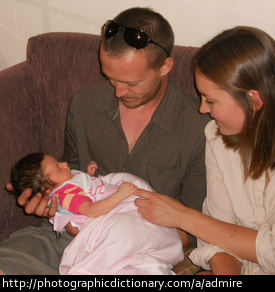 Parents admire their baby.