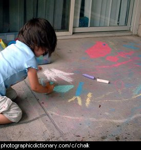 Photo of a child drawing with chalk