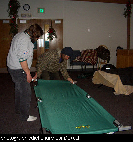 Photo of some people setting up a cot