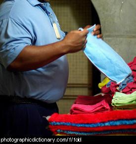 Photo of a man folding clothes.