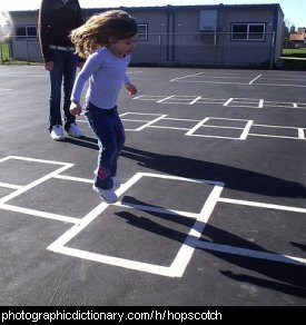 Photo of a child playing hopscotch