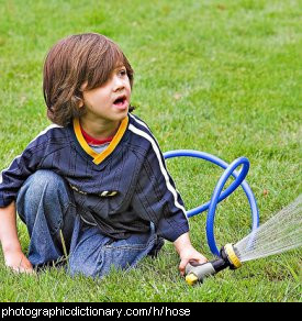 Photo of a boy holding a hose