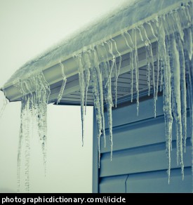 Photo of icicles hanging from the roof of a house.