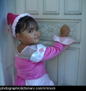 Photo of a little girl knocking on a door