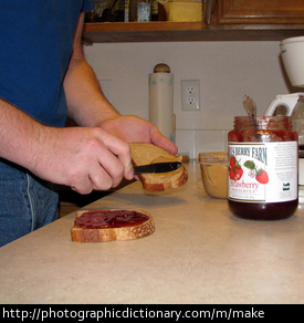 Photo of a man making a peanut butter and jelly sandwich