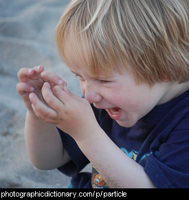 Photo of a child examining some grains of sand