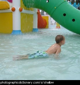 Photo of a child in a shallow pool