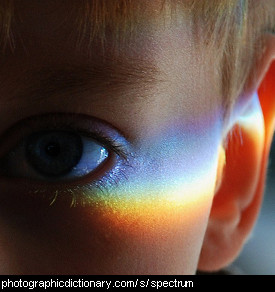 Photo of a boy with a rainbow on his face