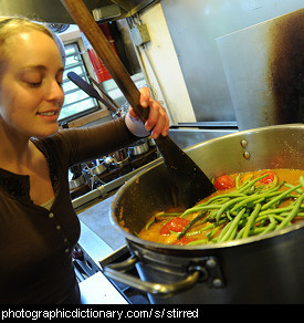 Photo of someone stirring a pot of soup