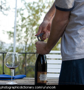 Photo of a man opening a bottle of wine